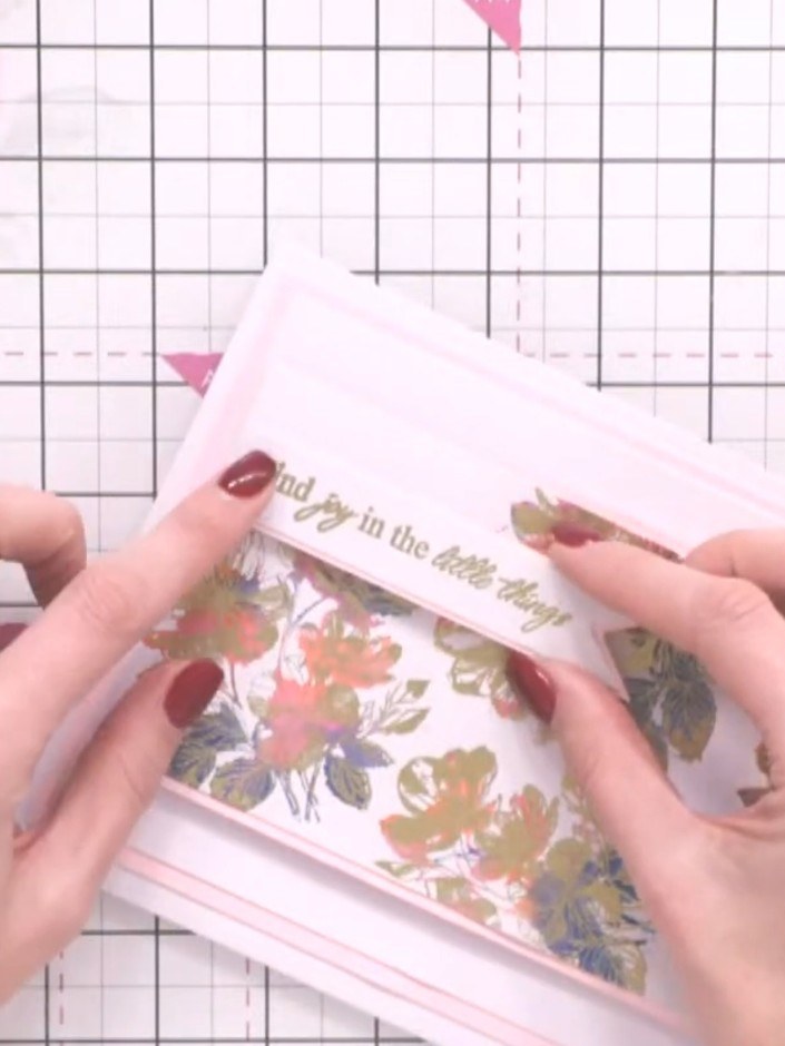 Step 11: Adhere the sentiment banner across the front of the card, positioning it over the floral design. Use adhesive 