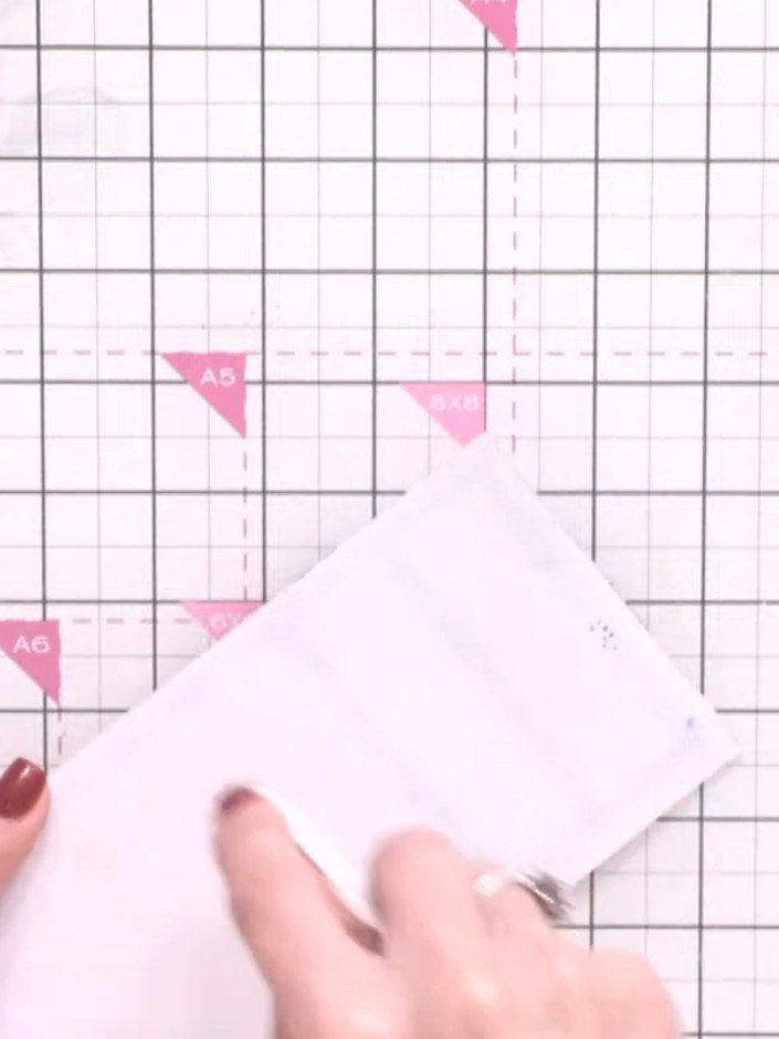 Step 8: Layer the decorated white panel onto the pink mat, then attach both layers to the white card base using adhesi