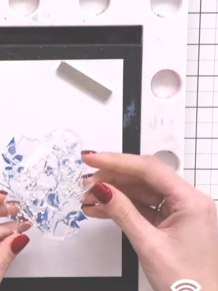 Step 7: Position the blue floral detail stamp on top of the dried watercolour base and press firmly to stamp the image