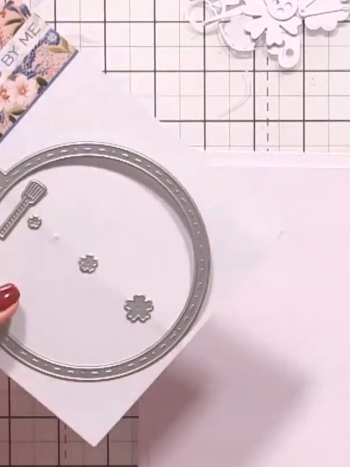 Step 6: Die-cut the sewing machine from white cardstock. Arrange small floral die-cuts around the machine to create a 