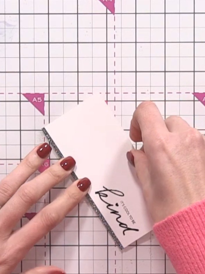Step 12: Stamp your chosen sentiment in black ink onto the white card base, positioning it to one side of your painted 