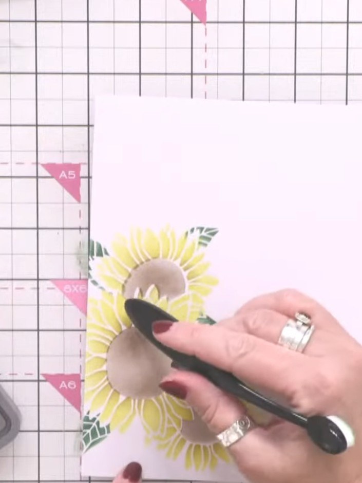 Step 4: Apply glitter paste dye over the sunflower design using a palette knife to add texture and sparkle, creating d