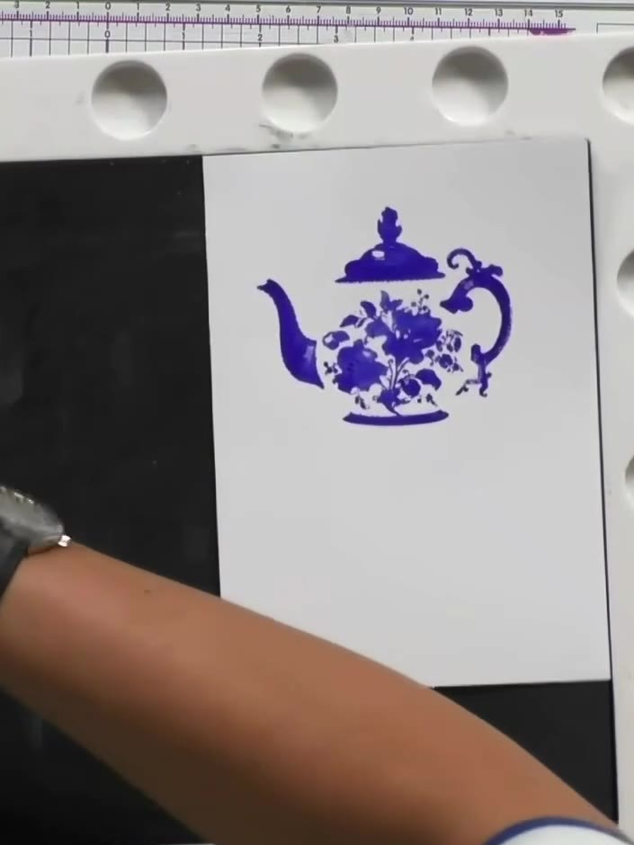 Step 8: Press the stamped teapot image firmly with your hand to ensure all the fine details have transferred clearly o