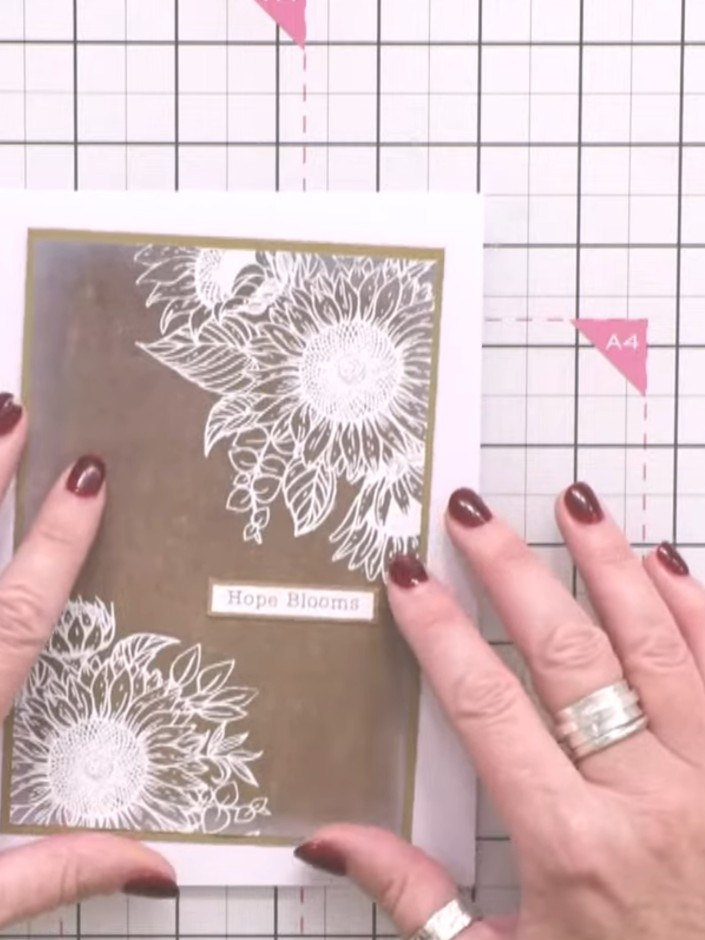 Step 5: Stamp and heat emboss the floral design in the opposite corner of the card front using white embossing powder.