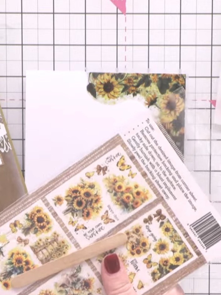Step 7: Apply rub-on corner elements from the Hope Blooms A6 Rub Ons sheet to frame the sunflower focal points on your