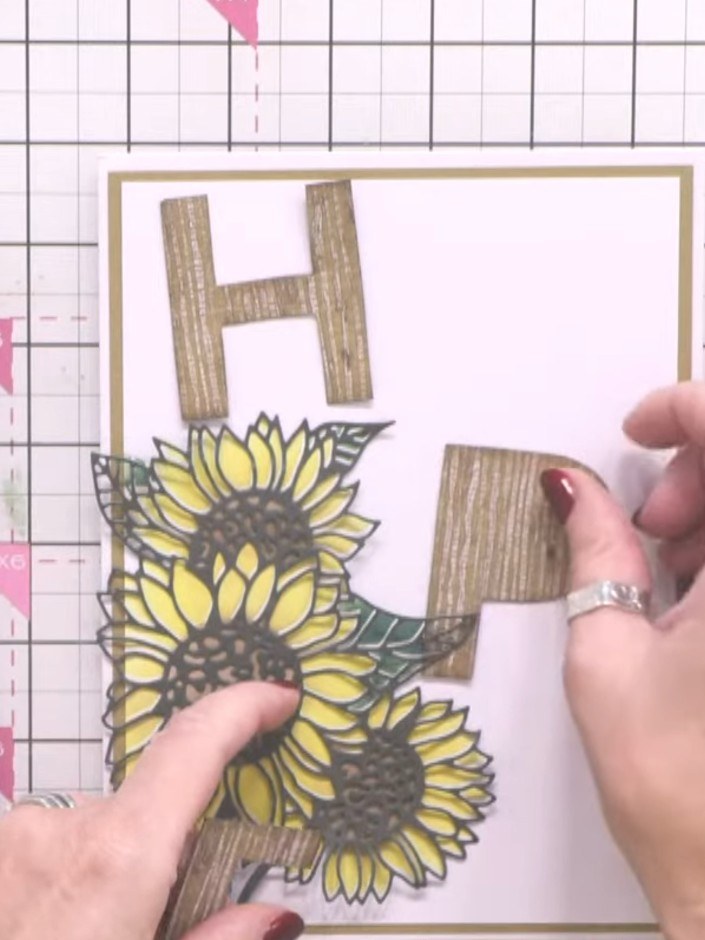 Step 3: Layer the diecut sunflower onto patterned paper from the Hope Blooms collection, positioning it as your focal 