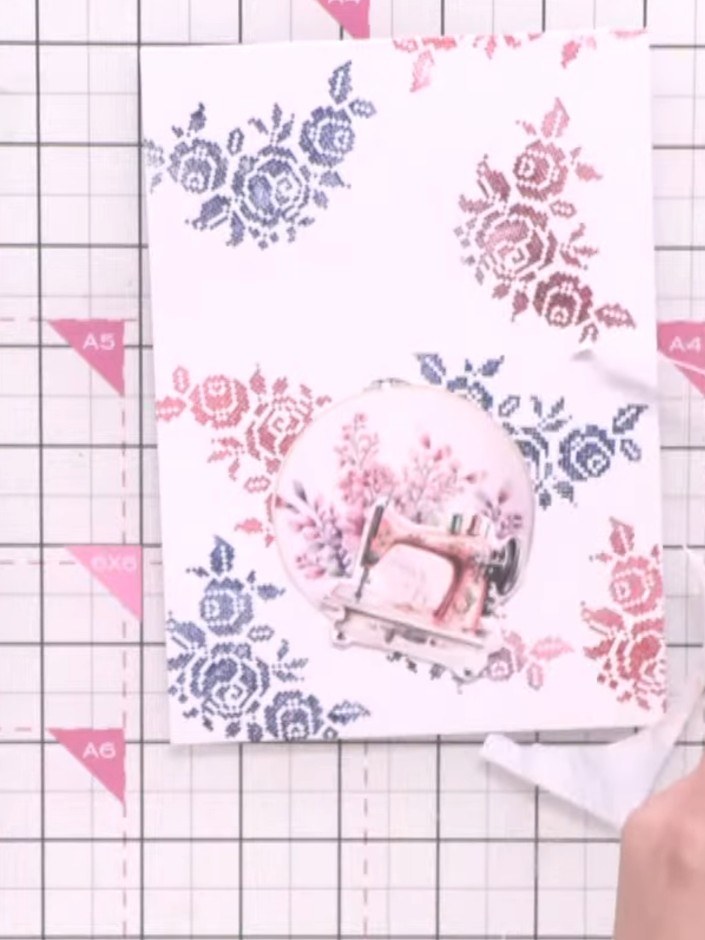 Step 6: Layer the die-cut embroidery hoop onto the blended floral background card using foam pads to add dimension.
