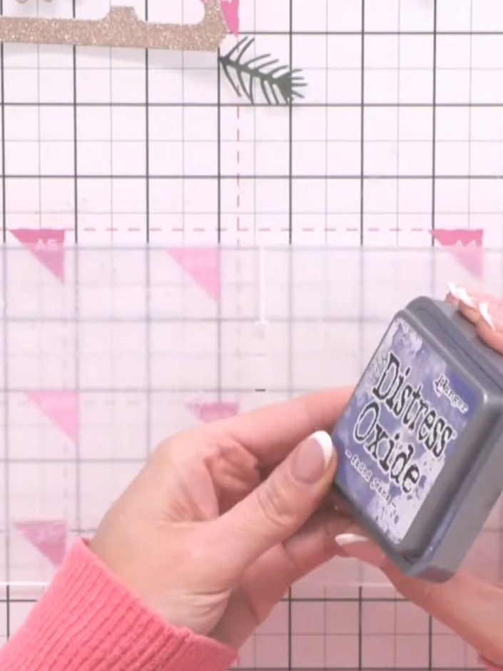 Step 1: Ink both sides of the snowflake frame embossing folder using a vintage blue Distress Oxide ink pad, swiping th