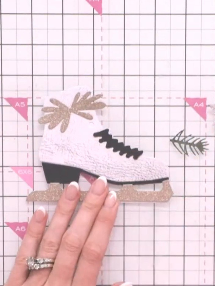 Step 8: Layer the foliage pieces and embellishments around the top of the ice skate boot. Build up dimension by adding