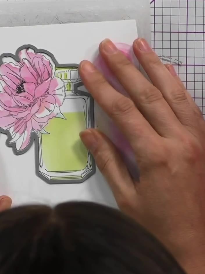 Step 7: Place the die-cut perfume bottle and flower piece into an embossing folder, positioning it at the front of the