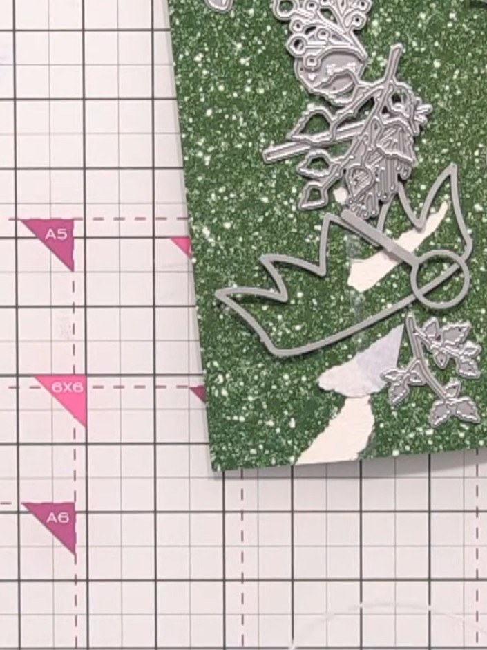 Step 1: Take a card with a hinge and position the largest elf hat die so it hangs over the top edge of the card to cre