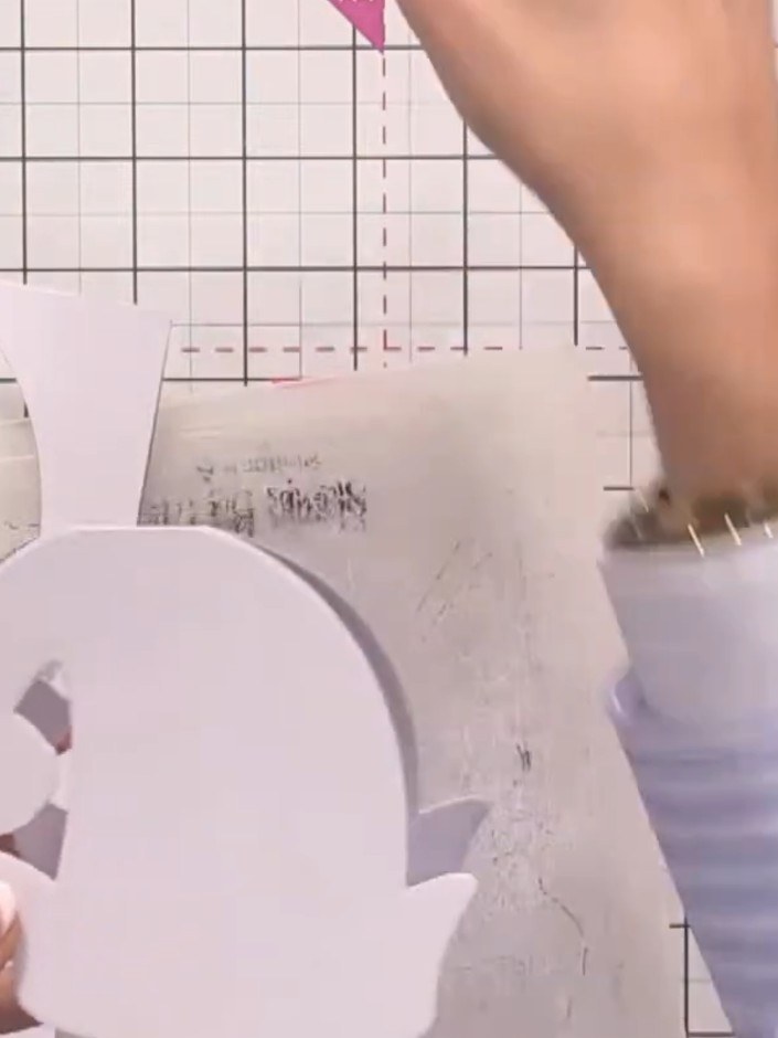 Step 3: Cut a second elf hat from white sparkle paper using the same die. The cut pieces will be visible on your cutti