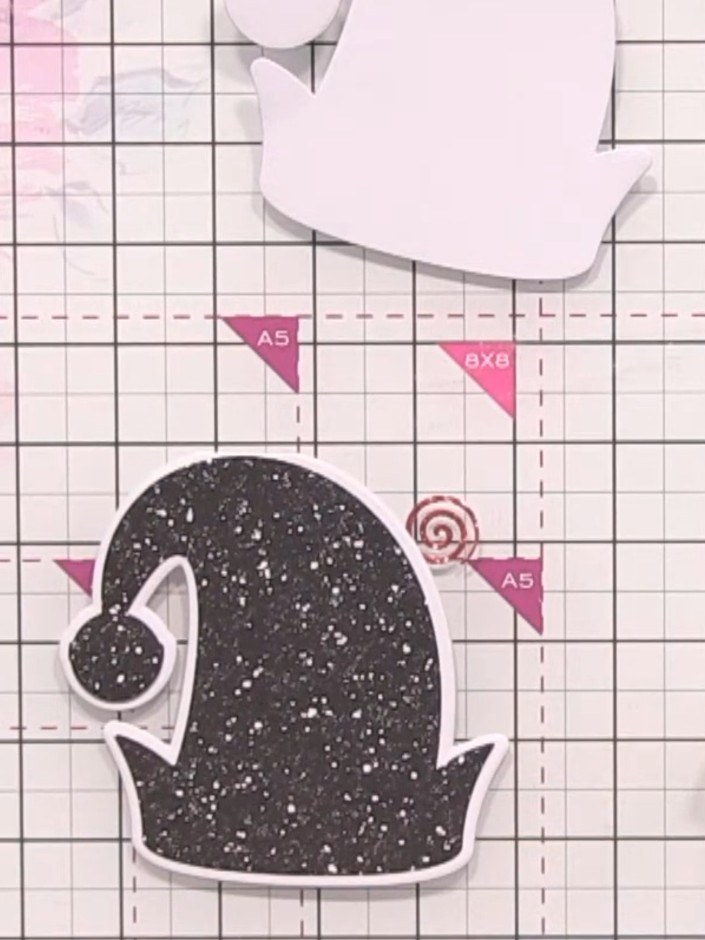 Step 7: Position the black glittery hat base onto your card base. Apply glue to the back of the hat and secure it to t