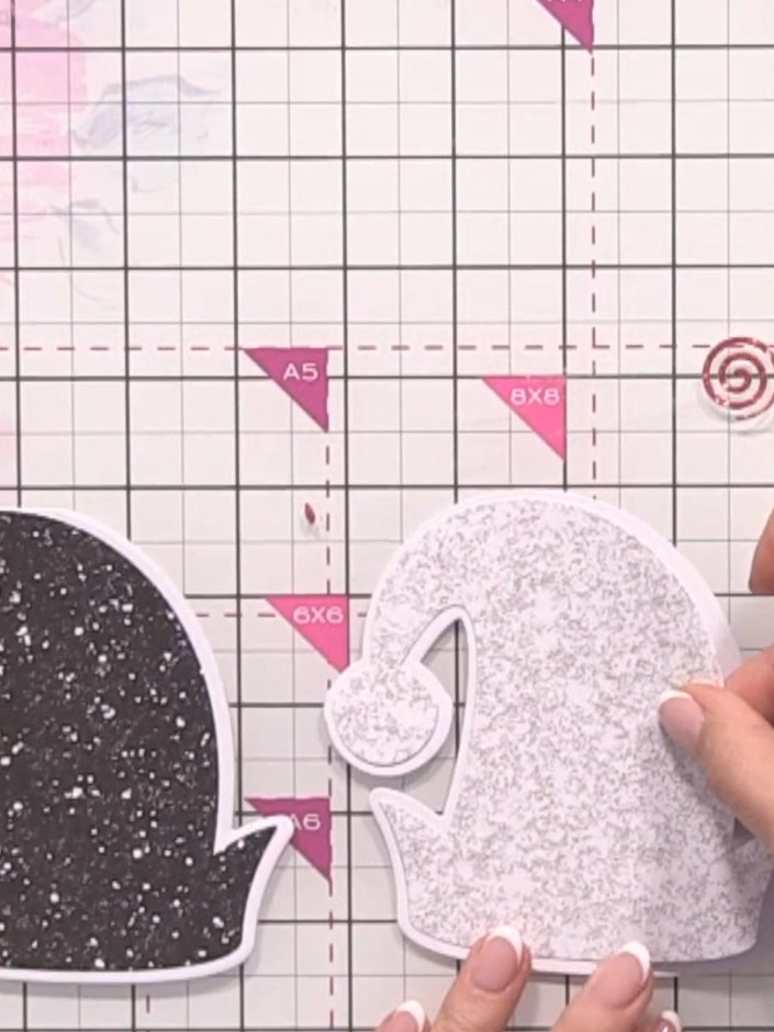 Step 8: Layer the white glitter hat piece on top of the black glitter hat piece, aligning them carefully. Secure in pl