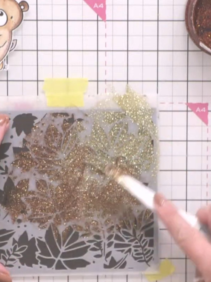 Step 3: Without removing the stencil, pick up spellbound Stella paste with a brush and layer it over the champagne pas