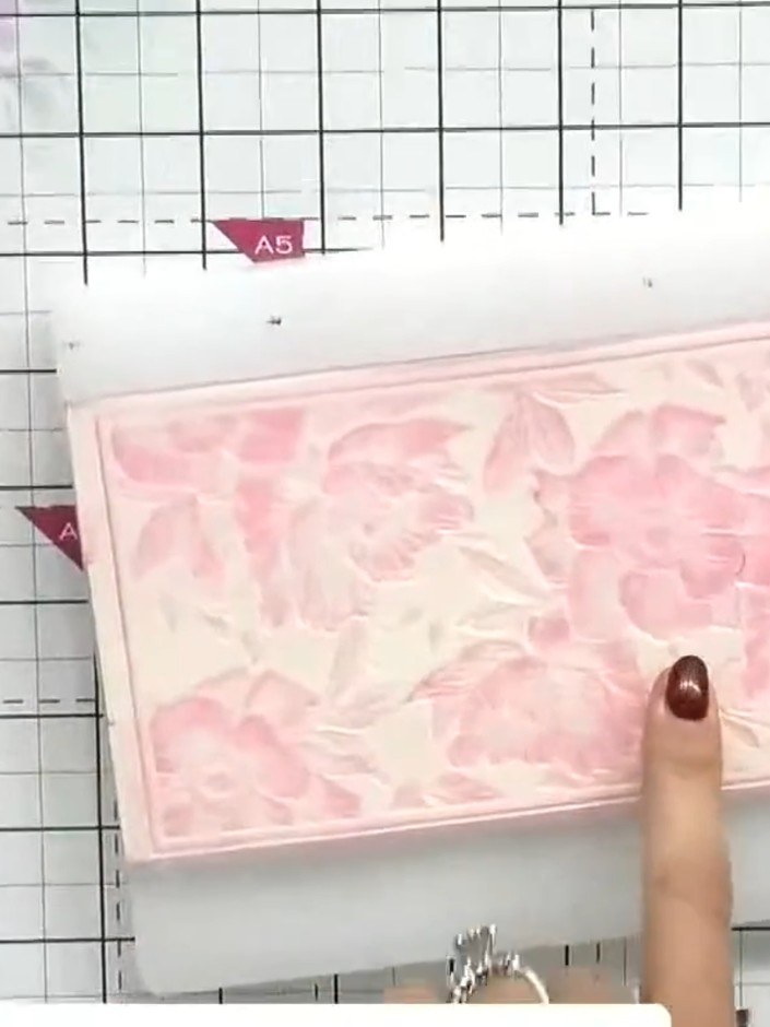 Step 7: Apply a darker pink ink to the embossing folder. Run the card through the die-cutting machine again in the sam