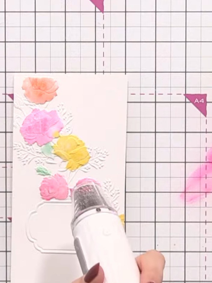 Step 5: Dry the card completely using a heat gun, holding it over the watercoloured flowers and embossed background un