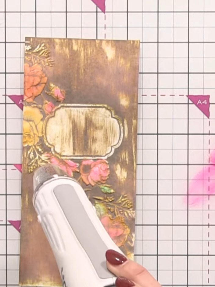 Step 9: Apply white ink from the ink pad directly onto the raised embossed design on the card. Run the card through th