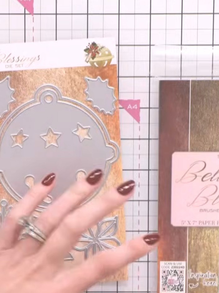 Step 1: Select the pink brushed steel effect paper from the Bells & Blessings paper pad. Use the bell die from the A5 