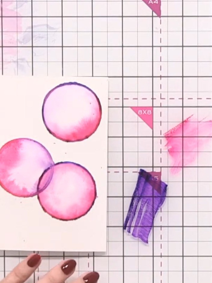 Step 10: Use a paintbrush to add splats of leftover ink colours across the card for an abstracted watercolour effect. K