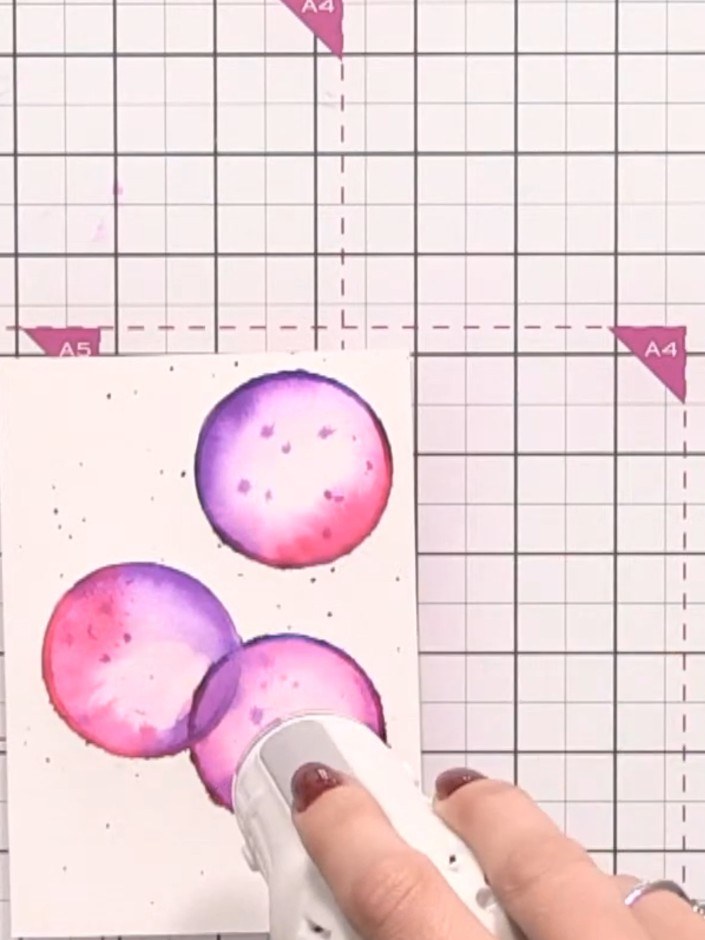 Step 11: Dry the card completely using a heat gun. Hold the heat gun over the watercoloured bubbles until all the ink i