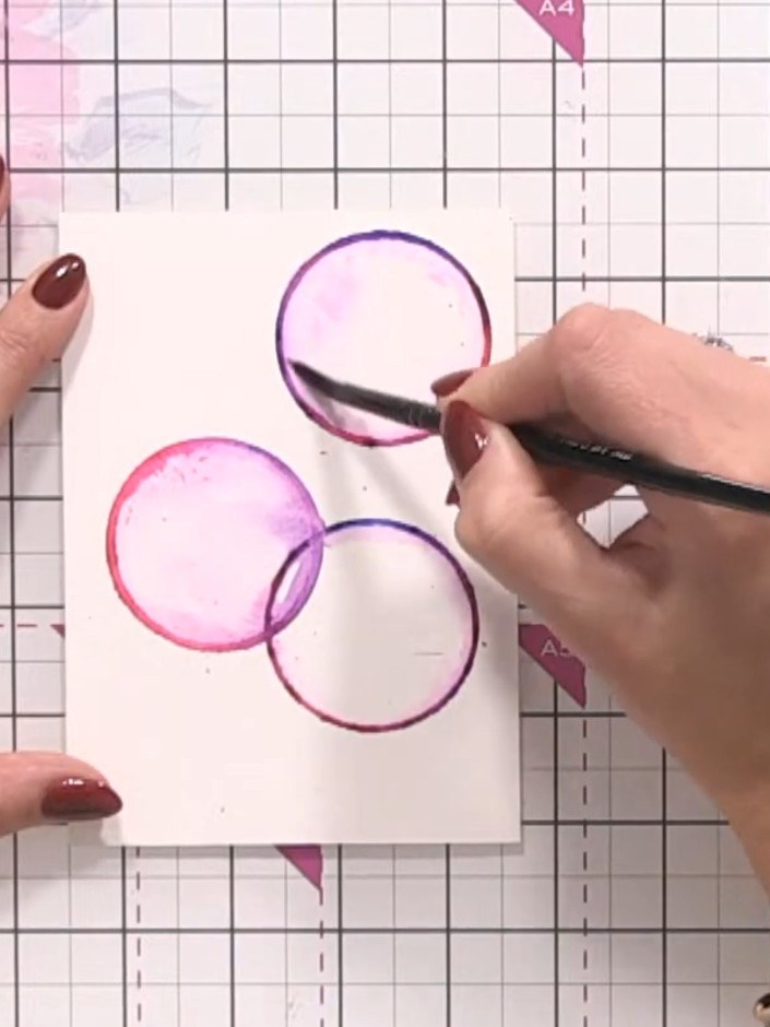 Step 7: Using your brush, pull the colour outward from the edges of each circle towards the centre to create a bubble 