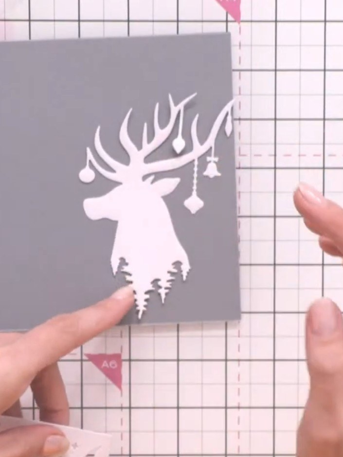 Step 1: Die cut the large reindeer panel design from white card stock. This creates the white silhouette that will for