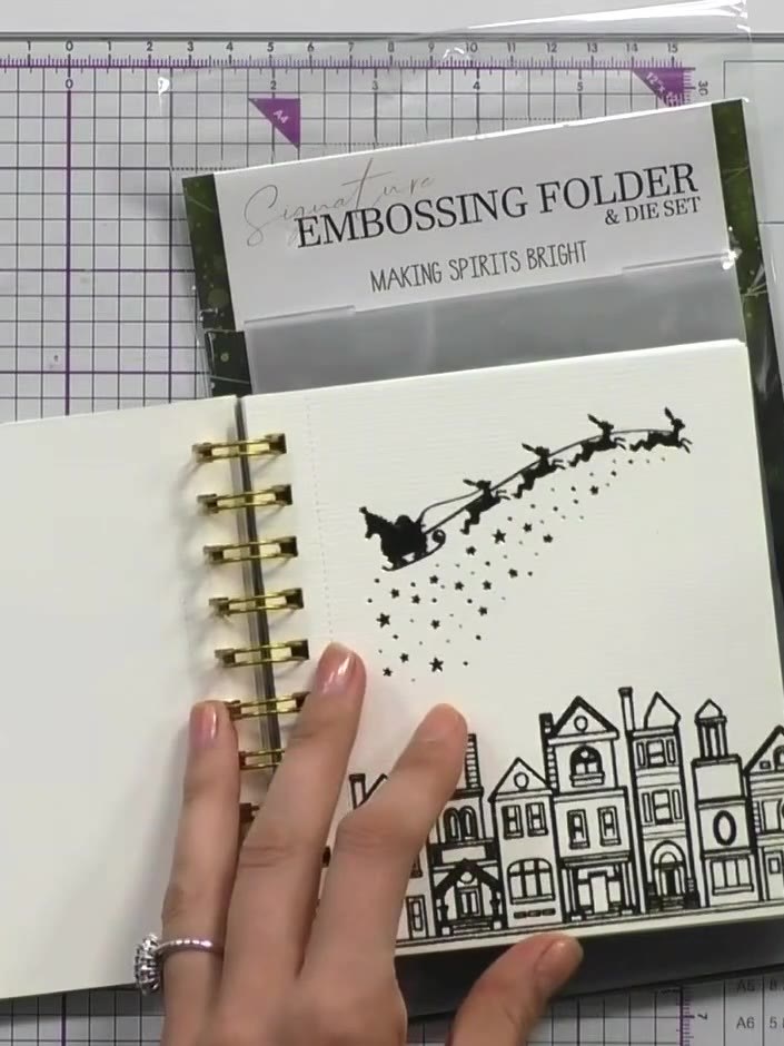 Step 1: Open the ring-bound foil colouring book to reveal the festive scene pages. Select a page you wish to colour - 