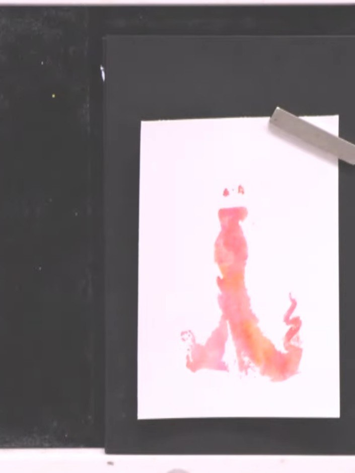 Step 9: Stamp the outline of the gown firmly over the watercoloured image to complete the lamination effect. Ensure th