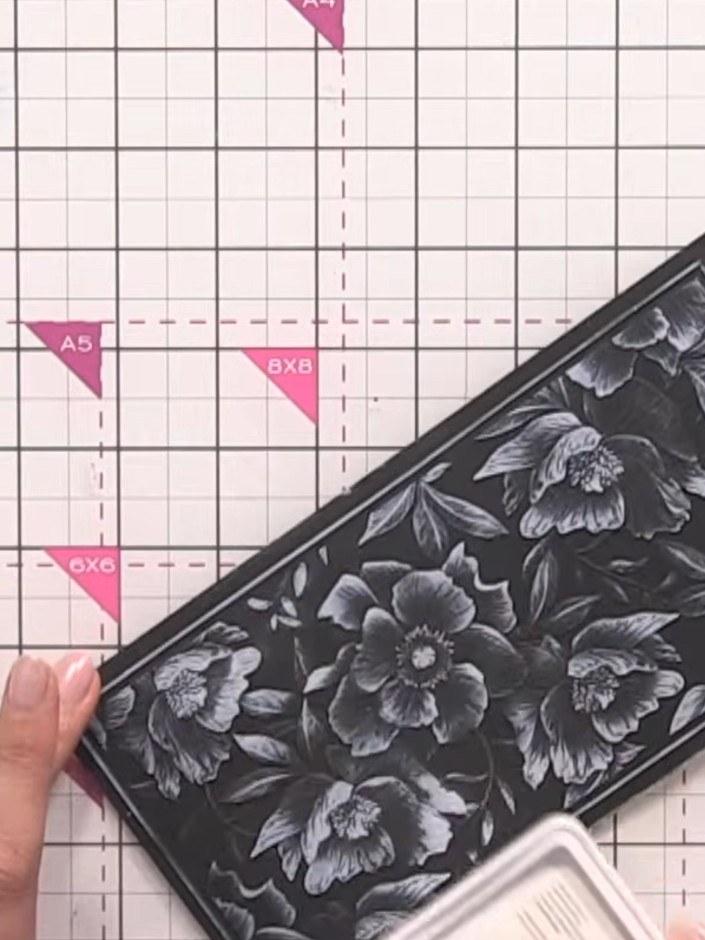 Step 1: Cut white cardstock to size and place it into the embossing folder with the floral design. Position the cardst