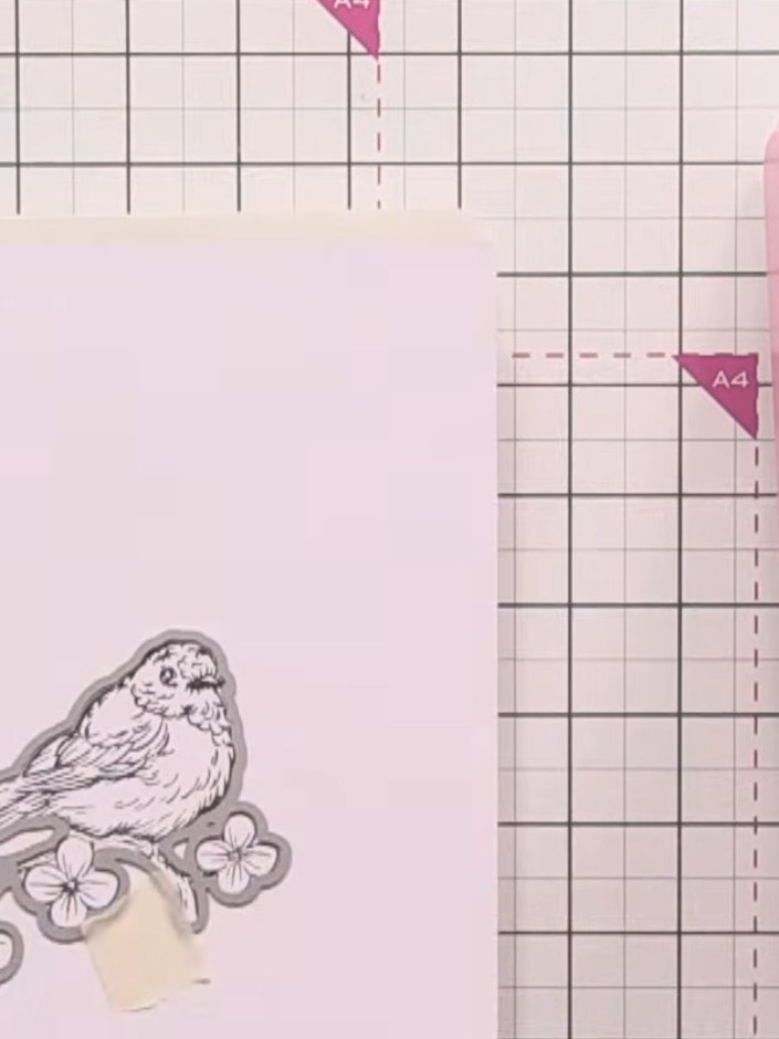 Step 7: Secure the die-cut bird stamp to your card base using tape or adhesive. Position the bird motif with the flowe