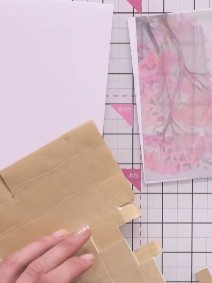 Step 5: Build a frame of foam pads around the entire back edge of the aperture on the kraft card base, ensuring they c