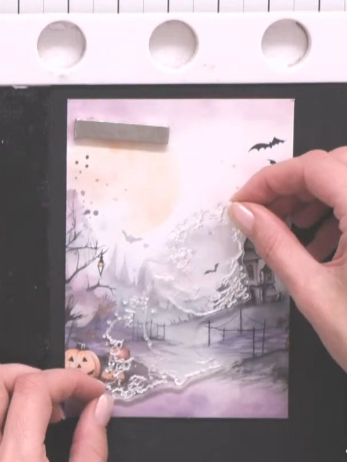 Step 1: Select a piece of patterned paper from the Creepy Chronicles pad. Position it on your black card base to creat