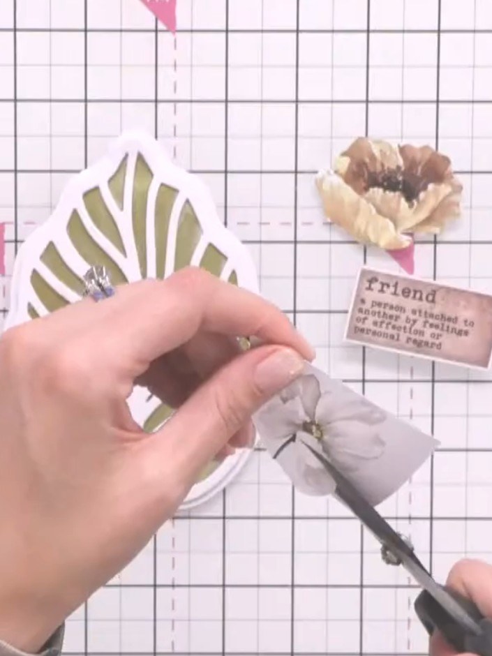 Step 11: Attach a sentiment label to your card. Position it near the top of the card, above the floral wreath design.