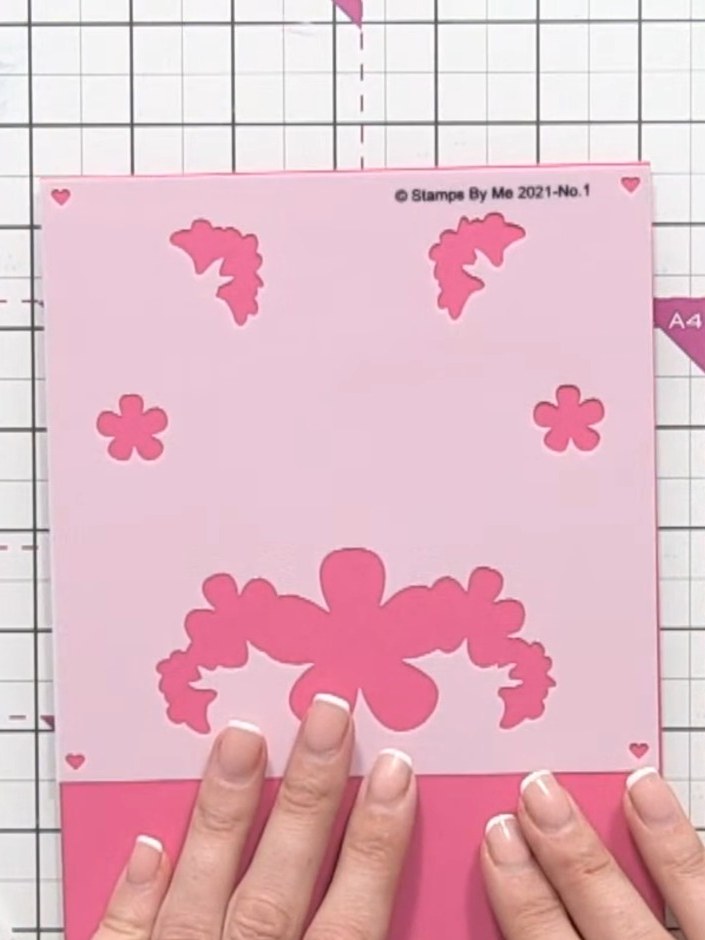 Step 1: Start with a pink card blank as your base. Position the layering stencil on top to plan your design.