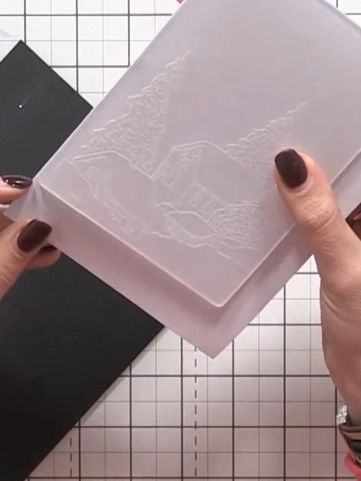 Step 4: Place the white card into the Winter Village embossing folder. Run the folder with the card through your die-c