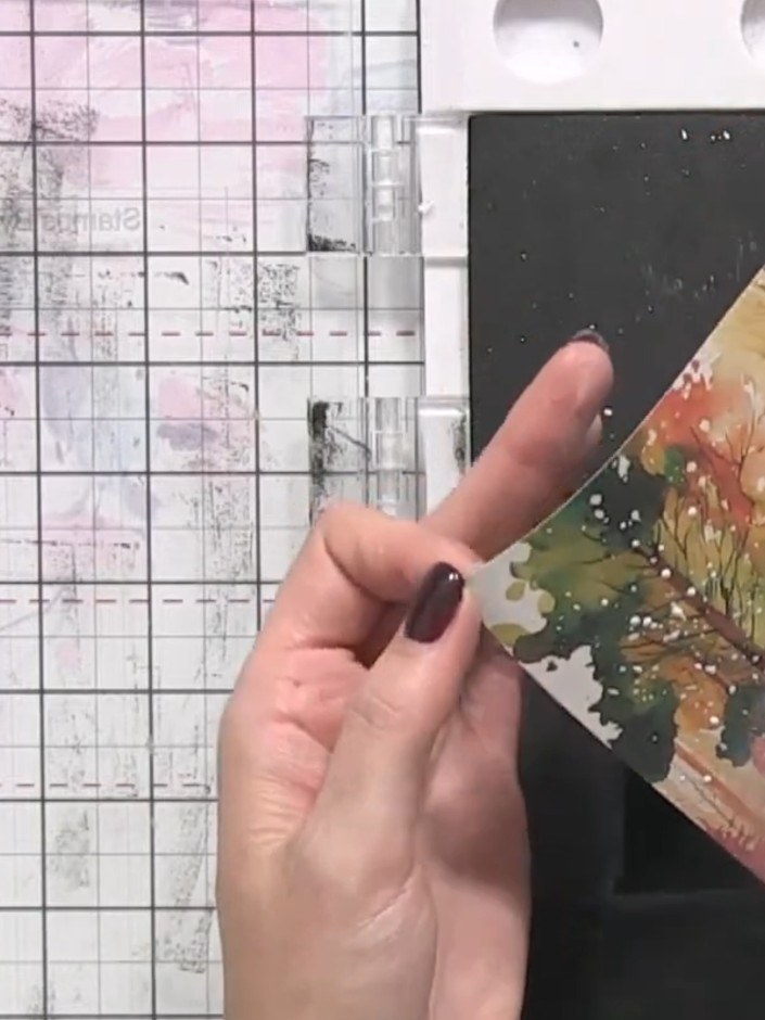 Step 7: Carefully peel away the stencil mask from the card to reveal the white snow effect beneath. Allow the white pa
