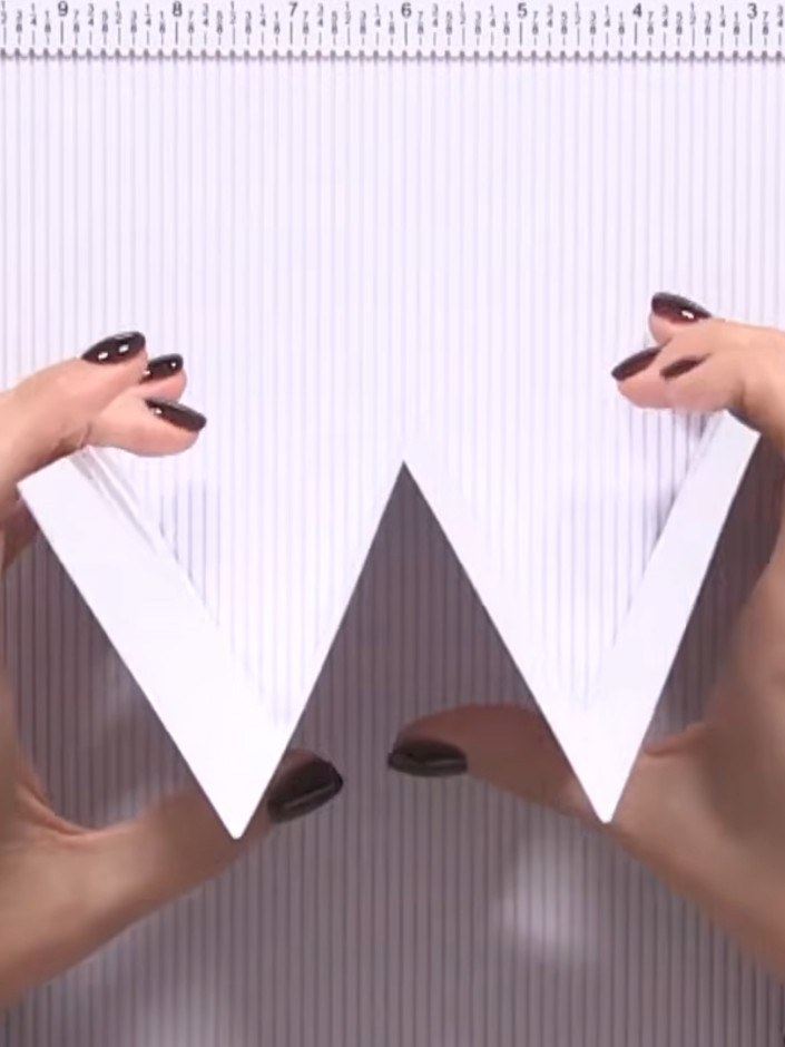 Step 5: Take the smaller white card blank and fold it back on itself. Position it over the dark grey triangular panel 