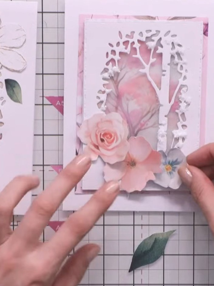 Step 4: Glue the flower arrangement in place on the card front, layering the pink rose, smaller pink flowers, and blue