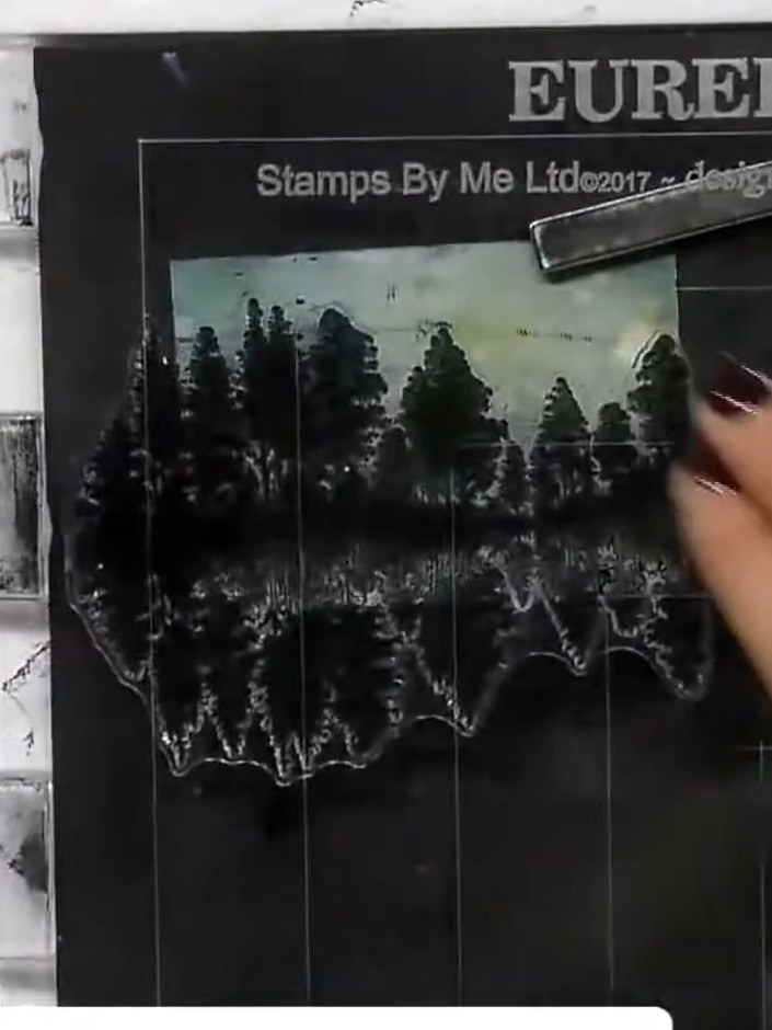 Step 7: Apply darker ink to the top portion of the tree stamp to create contrast in the sky area. Stamp the trees onto