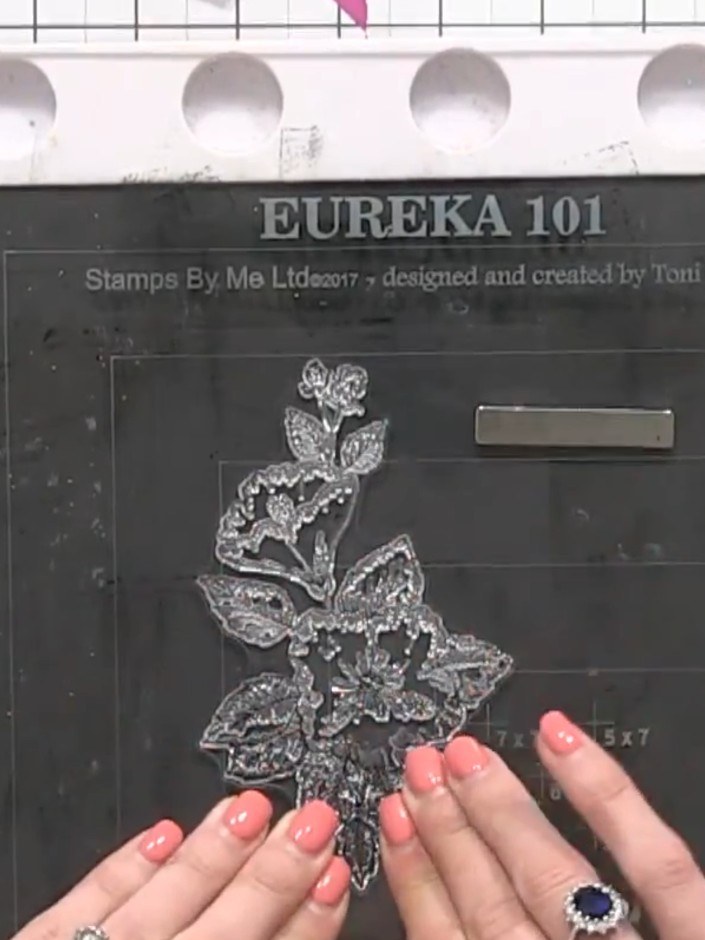 Step 4: Sprinkle the bonding powder generously over the stamped floral design on the black card. Ensure the powder cov