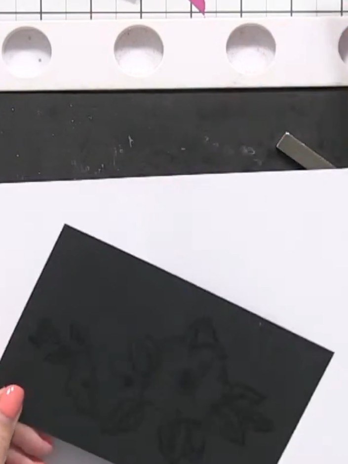 Step 5: Place the stamped black card stock onto white card stock to catch any excess powder. Use a heat gun to melt th