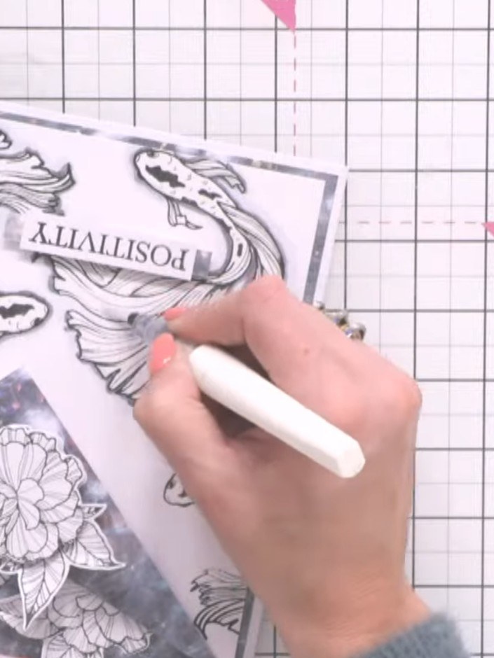 Step 14: Add sparkle pen details to the fish's tail and body to complete the card.