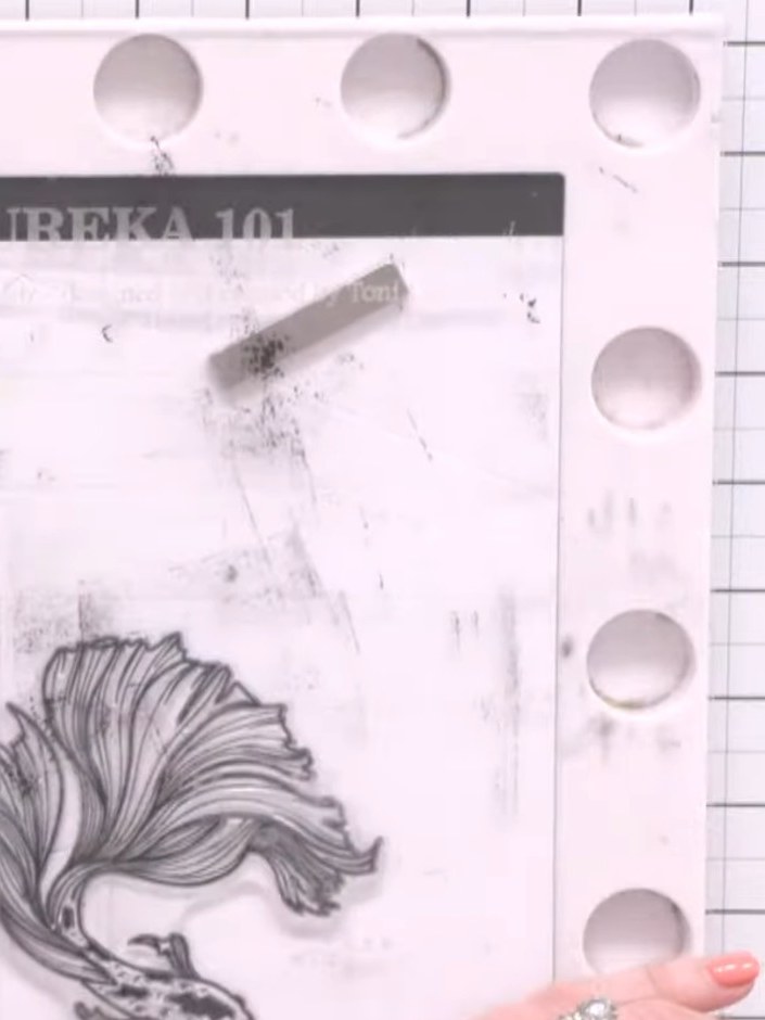 Step 5: Stamp the fish image from the Eureka 101 stamp set in black ink onto the white patterned paper, positioning it