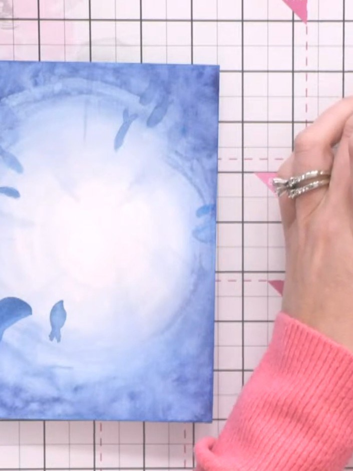 Step 9: Using a fine brush, add white confetti splashes across the card to represent sea foam and bubbles. This will p