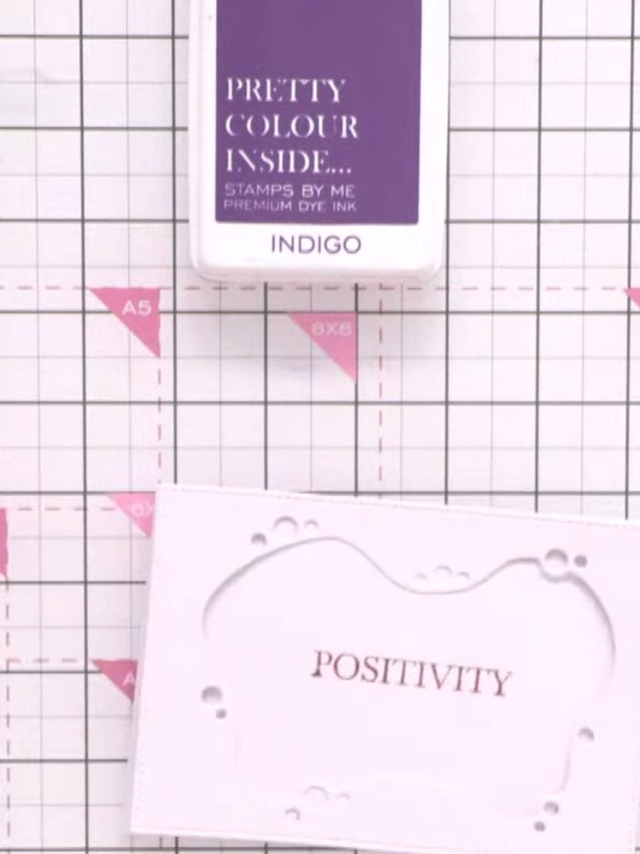 Step 4: Stamp the word 'POSITIVITY' onto your background card using the Bittersweet ink pad, positioning it to one sid