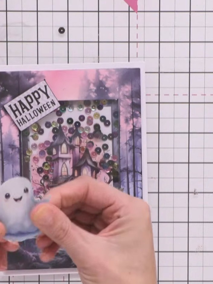 Step 14: Adhere the 'Happy Halloween' sentiment topper to the top corner of the card using foam pads to raise it above 