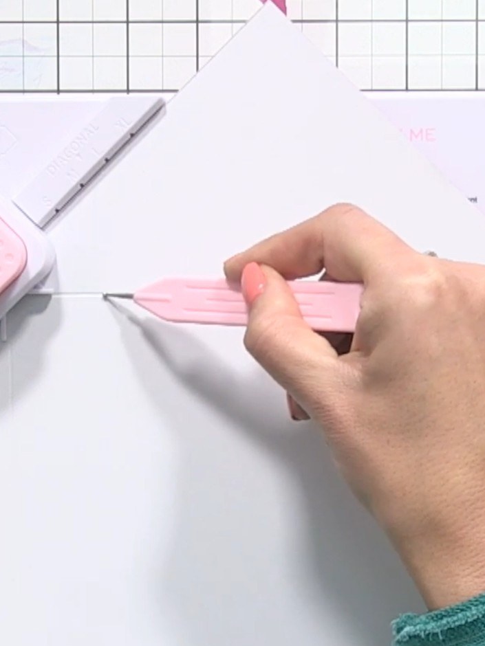 Step 3: Place the groove tool in line four of the envelope maker. Pull the tool down and then across the paper to scor