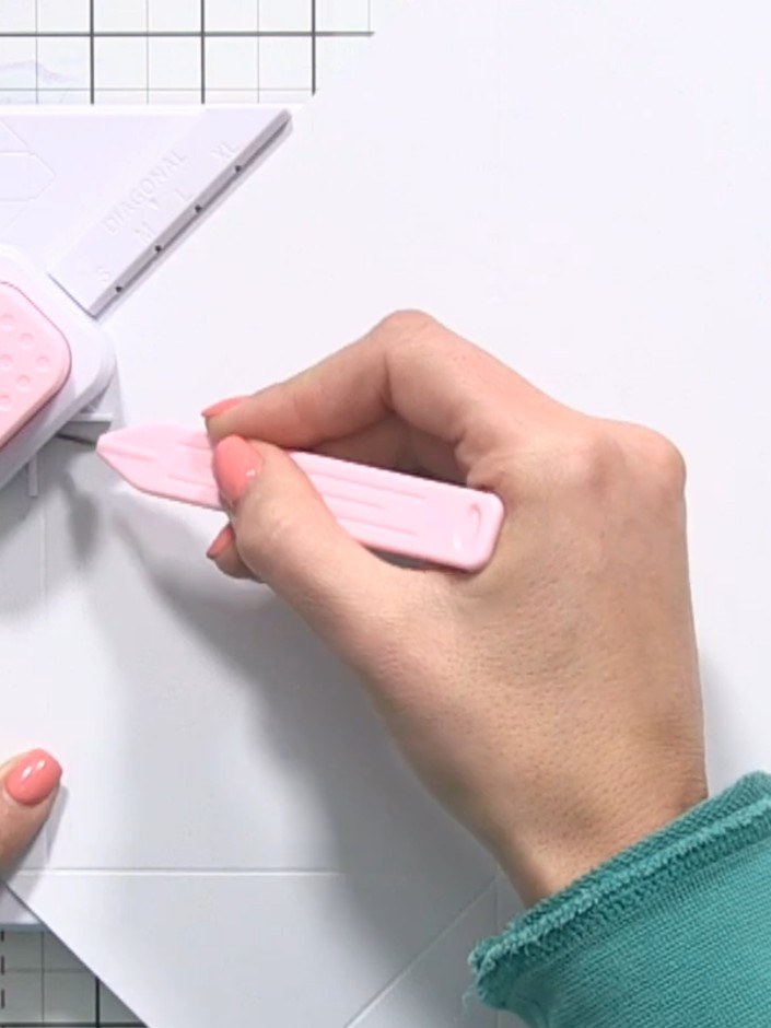 Step 6: Repeat the sequence for all four sides: twist the envelope maker to align with the XL marking, punch the corne