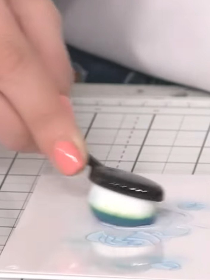 Step 3: Apply teal ink through the stencil using a blending brush with light pressure. Remove the stencil carefully to